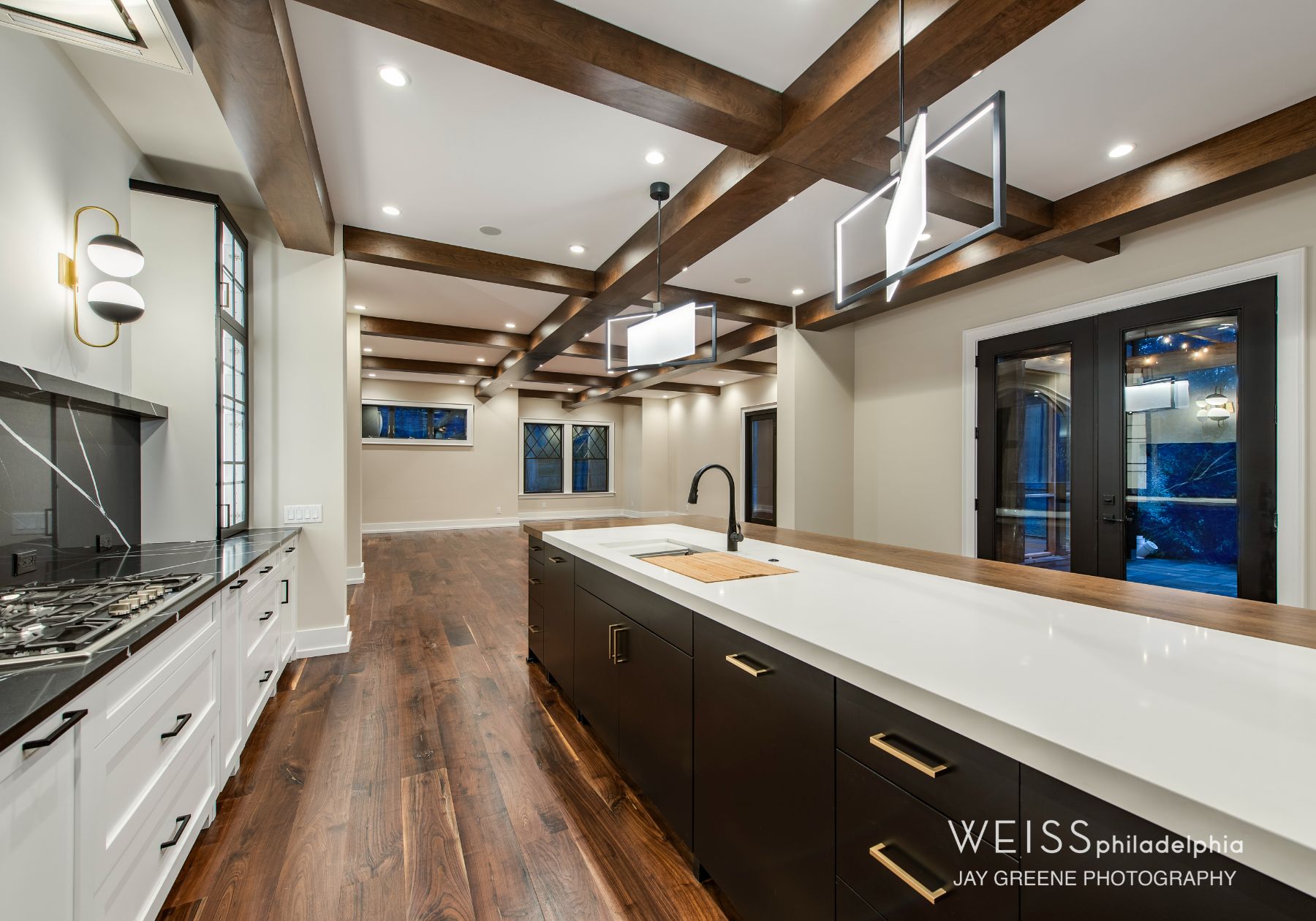 best custom homes wayne pa - design home studios - modern kitchen - dark cabinets - exposed beams - white countertops - globe lighting