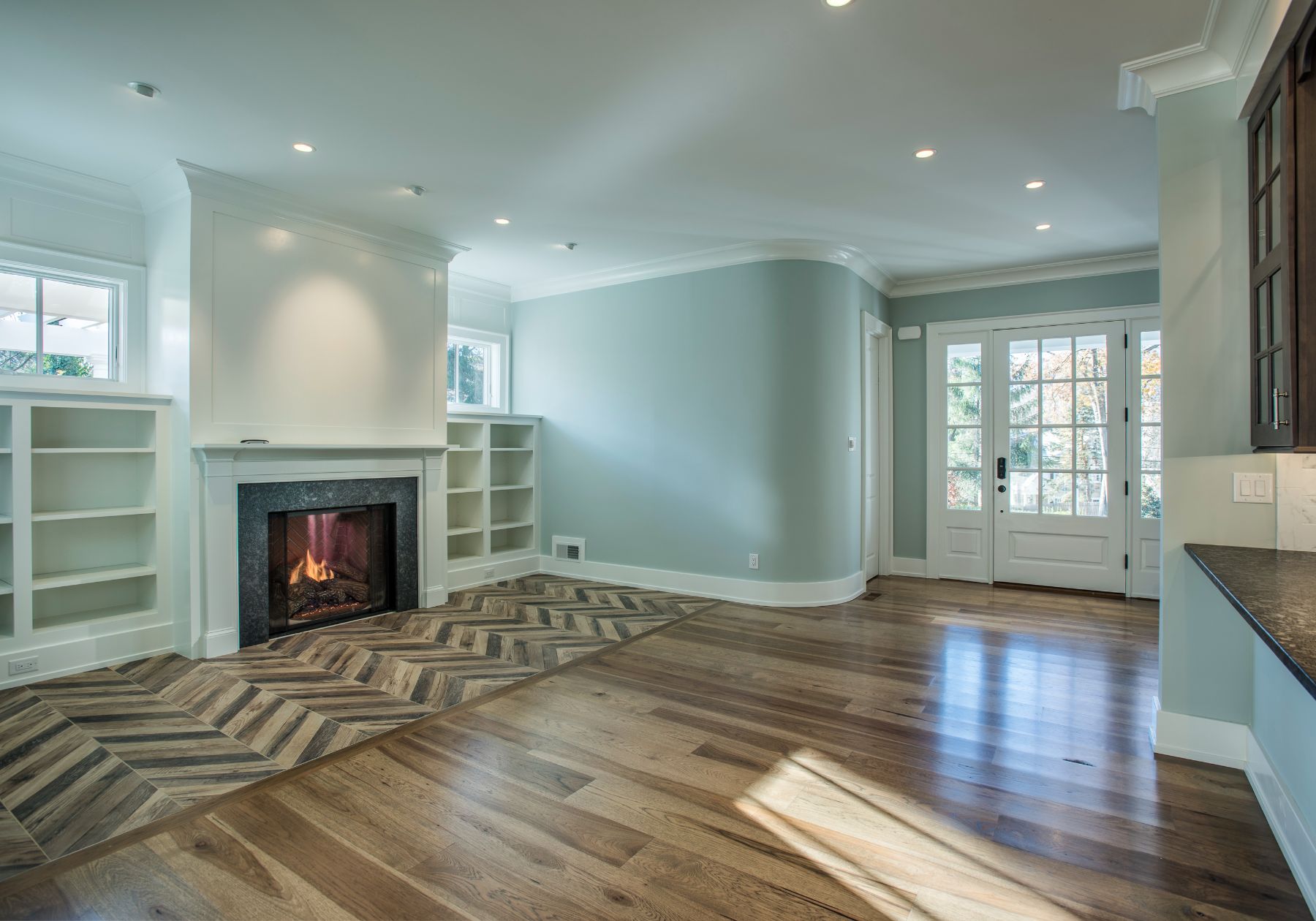 custom home builder Wayne pa - design home studios - blue living room - fireplace - chevron wood floors